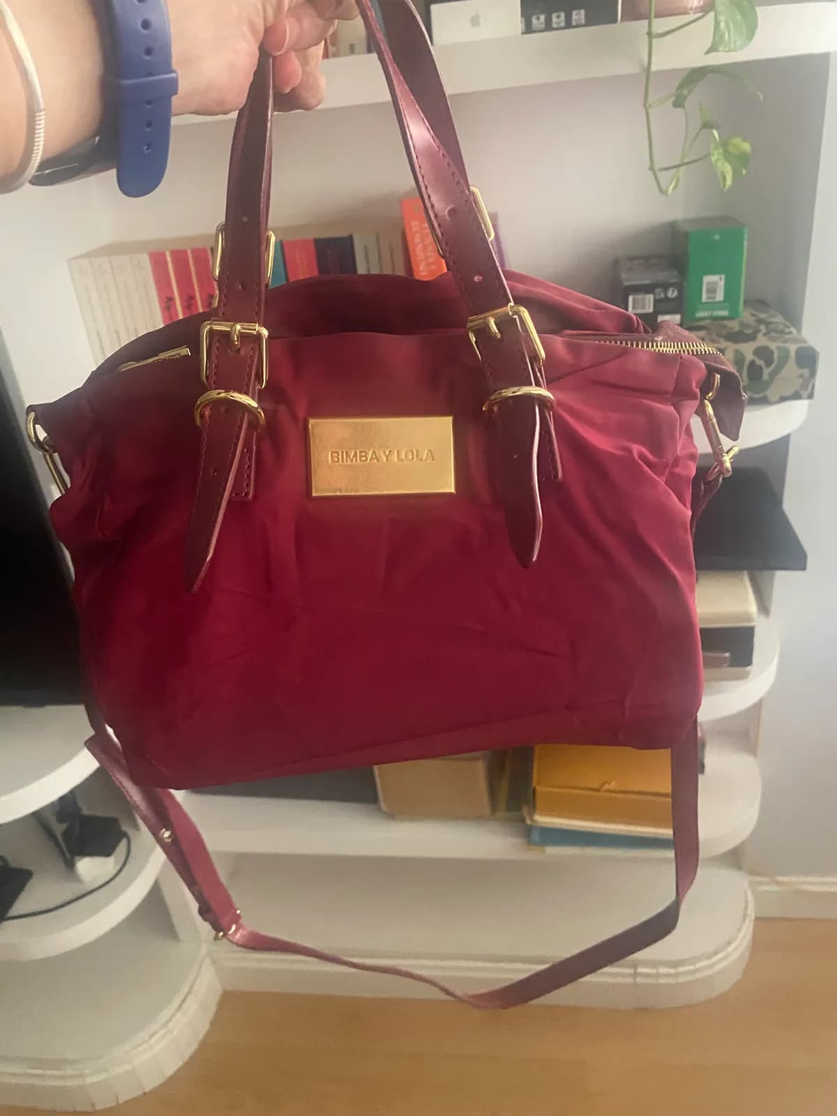 Bolso Bimba y Lola granate de nylon con asas de piel, placa dorada y correa de hombro.